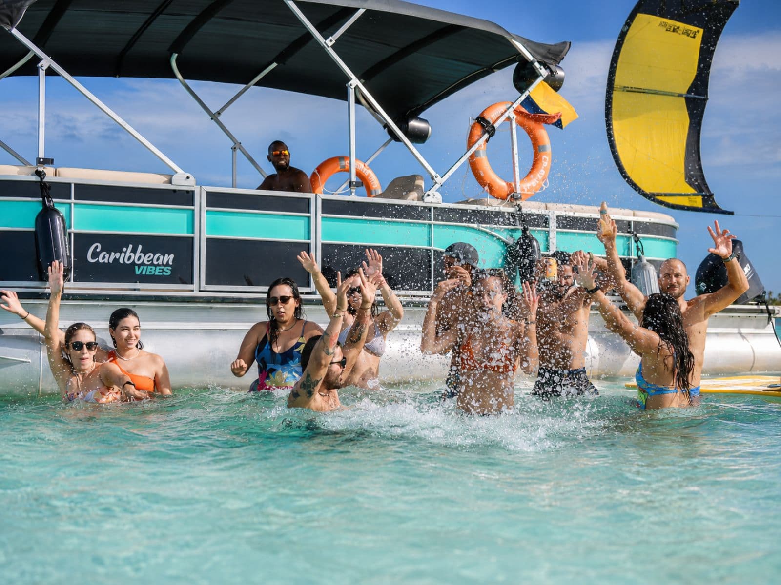 Travelers jump and celebrate in the turquoise water next to the pontoon